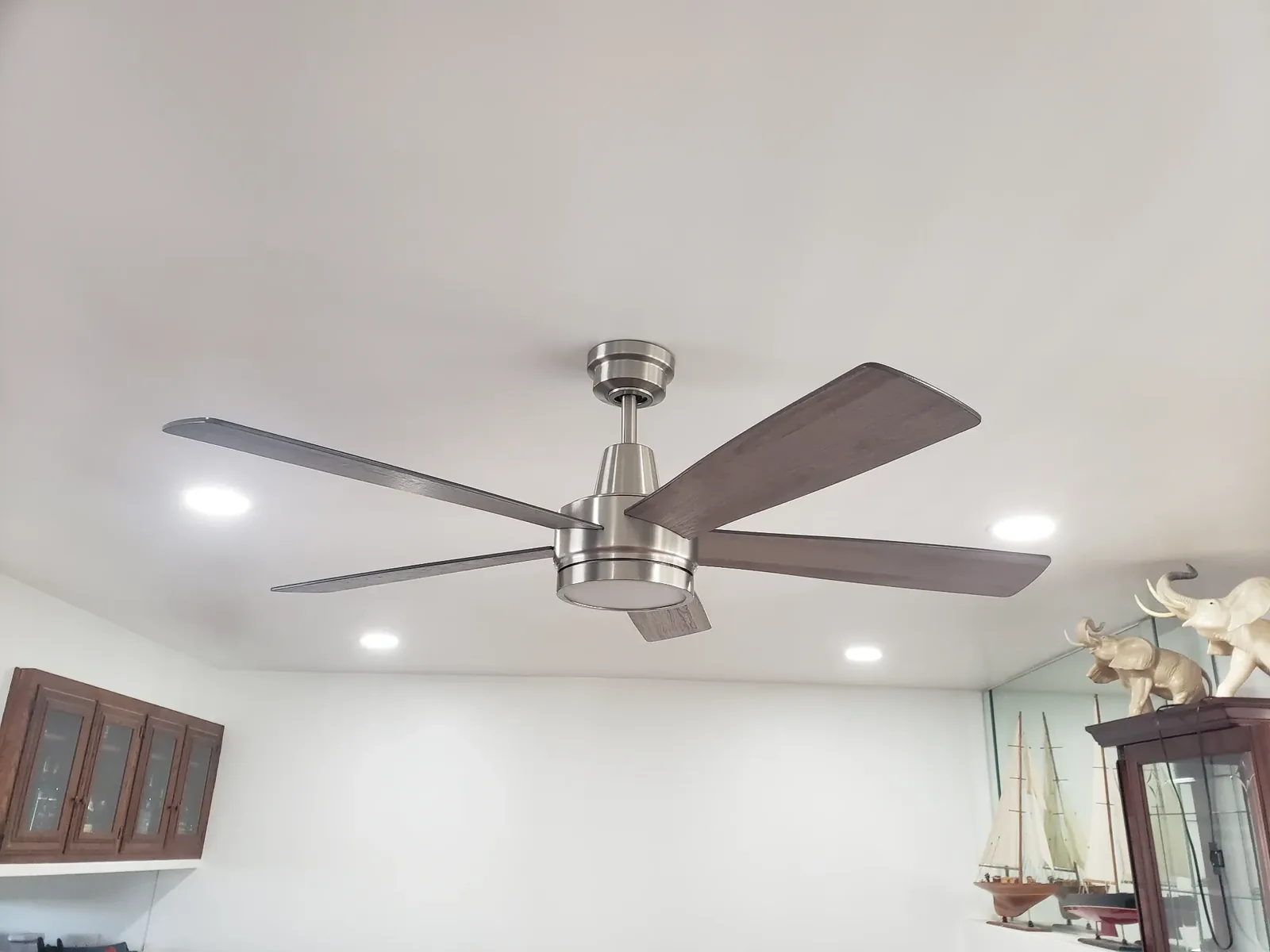 Modern ceiling fan with recessed lighting installation in a remodeled living space