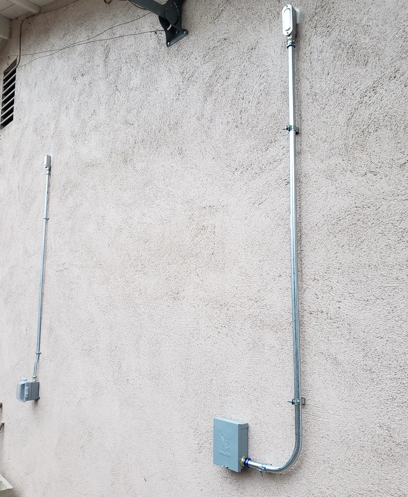 Exterior electrical conduit and weatherproof boxes installed on a residential wall